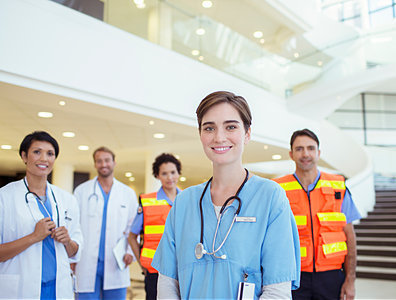 This is a group of medical professionals standing in a group in a brightly lit lobby.
